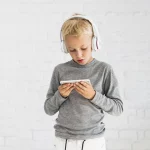 ©BCT-Ein-Beruf-mit-gesellschaftlicher-Bedeutung_little-boy-having-fun-with-smartphone-earphones