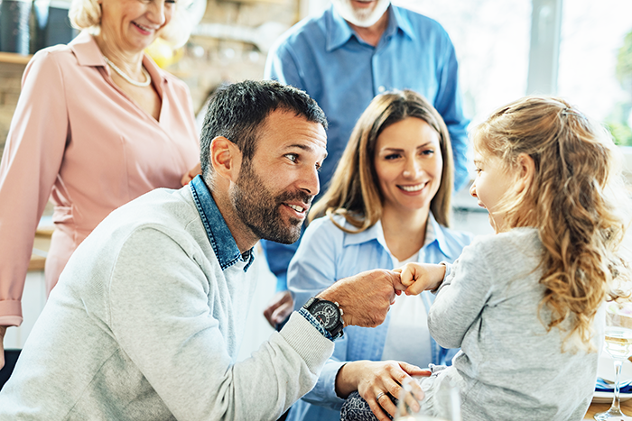 Dipl  Familiencoach©multi generation family enjoying time together home focus is happy father talking his small daughter making agreement with her 700px