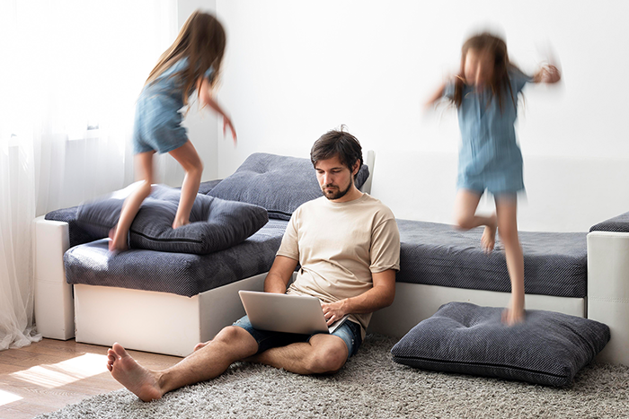 Familiencoaching Kommunikation©man trying work laptop from home while her children are running around 700px